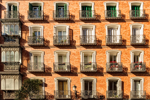 Red facade of traditional tenement house in Madrid, Spain