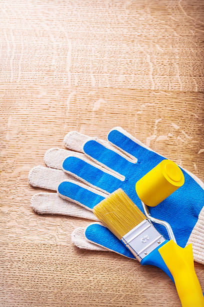 istock blue working glowes with paint brush and roller on wooden 476127852