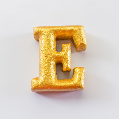 English alphabet made of wood spray paint gold.