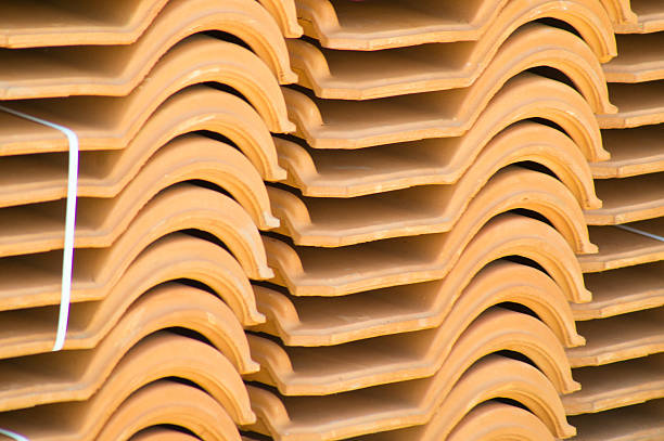 Preformed red roof tiles stacked in plies.  Construction materials, Background.