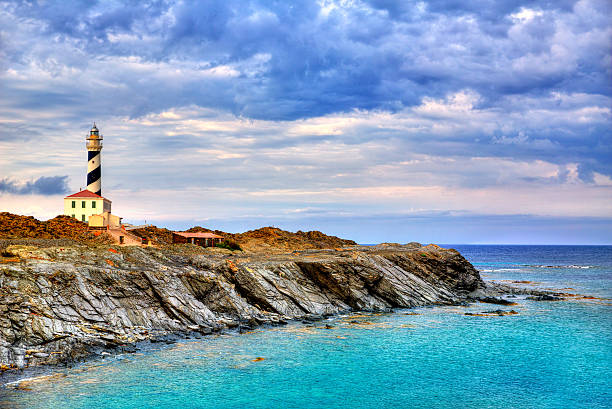 Cap de Favaritx sunset lighthouse cape in Mahon Cap de Favaritx sunset lighthouse cape in Mahon at Balearic Islands of Spain minorca stock pictures, royalty-free photos & images