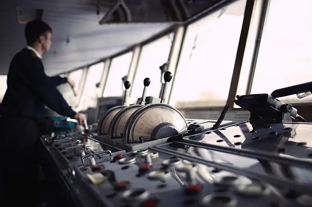 Photo of Navigation officer driving ship on the river.