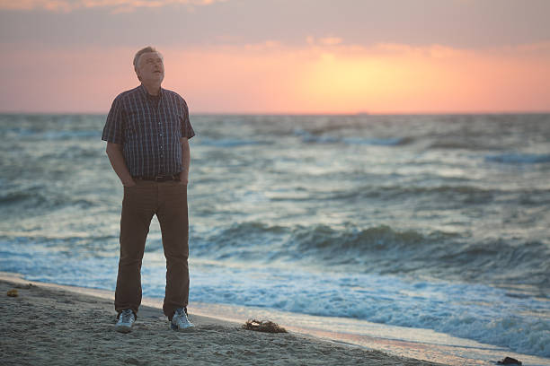 istock Man watching the sunrise on beach 476136740