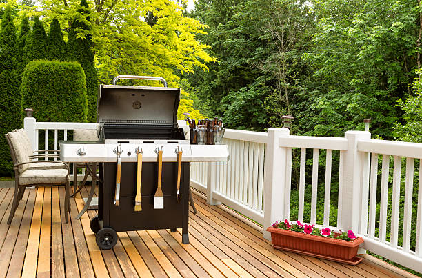 BBQ cooker and cookware ready to cook Photo of a clean barbecue cooker with cookware and cold beer in bucket on cedar wood patio. Table and colorful trees in background. patio deck stock pictures, royalty-free photos & images