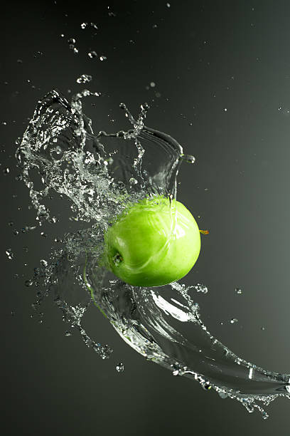 istock Green apple with water splash, on black 476139686