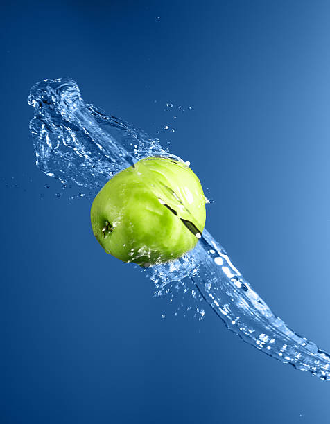 istock Green apple with water splash, on blue water 476139700