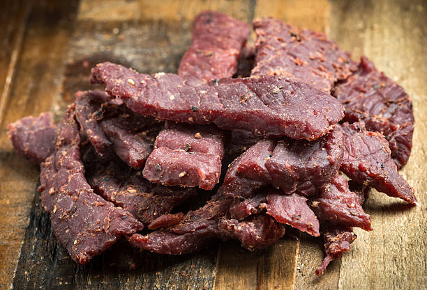 istock Pile of Beef jerky on wooden board. 476141131