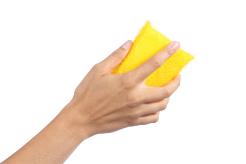 Woman hand holding a cleaning sponge isolated on a white background