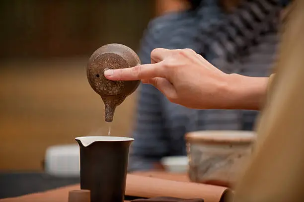 pouring the tea into the cup