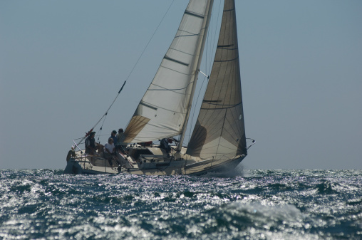 Crew on board yacht in competitive team sailing event