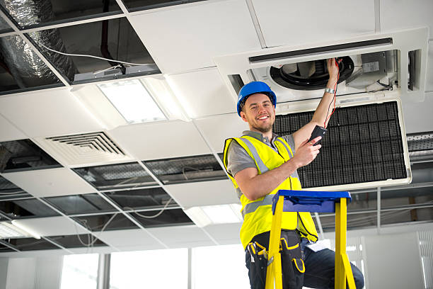 istock electrician fitting air conditioning to office interior 476147043