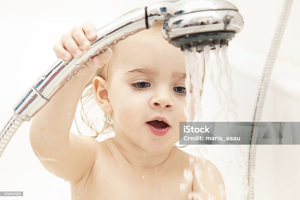 Baby showering Portrait of a baby playing with water 12-17 Months Stock Photo