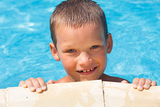 istock Boy in summer outdoor pool. 476148023