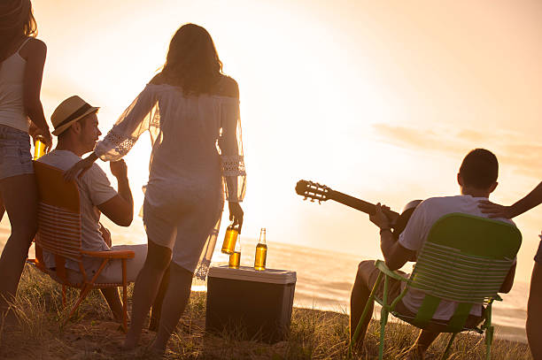 istock Relaxed friends beach party at sunset 476150835