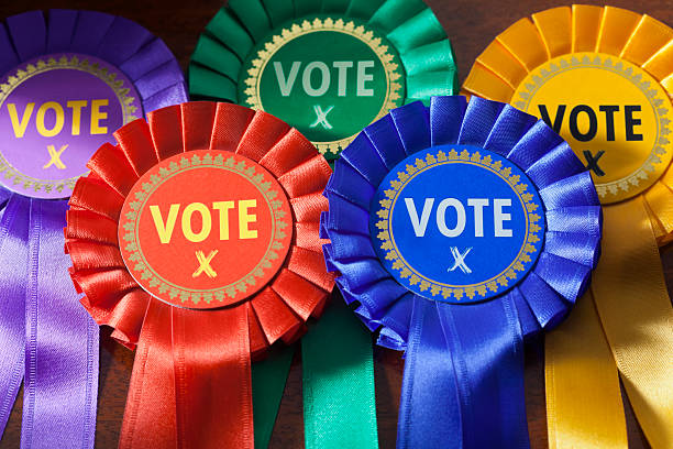 Voting in an Election Voting in a UK Election. Coloured Rosettes for the principal UK political parties award ribbon photos stock pictures, royalty-free photos & images
