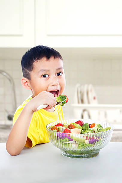 istock Asian child eating salad 476151272