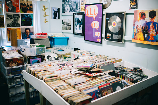 Records for sale, Record Shop. Pop music posters, advertising bands, on to the walls of a shop selling vinyl records. 