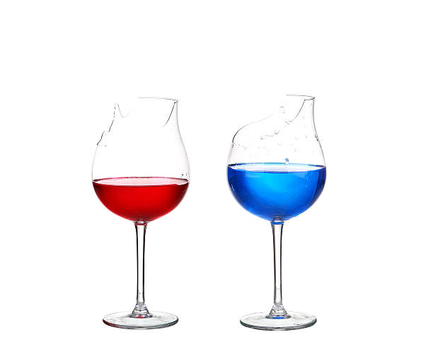 istock Two broken glasses with red and blue cocktail 476157800