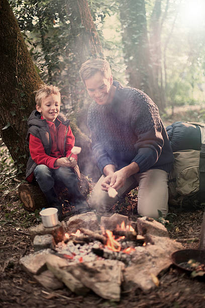 istock father and his son roasting marshmallows on a campfire 476158190