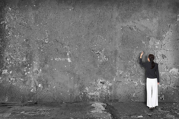 istock businesswoman writing on blank wall 476158654