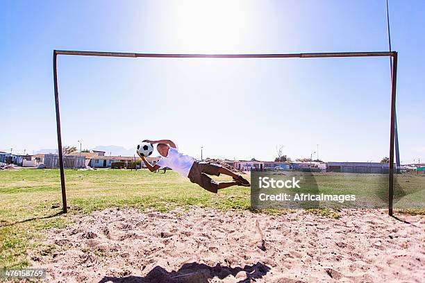 Young African Football Goalkeeper Saving The Ball Stock Photo - Download Image Now - Catching, Goalie, Africa