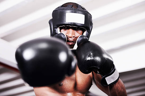 I'll take you one An african american boxer wearing protective gear standing in the ring headwear stock pictures, royalty-free photos & images