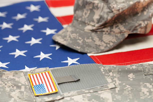 istock USA flag with US military uniform over it 476165448