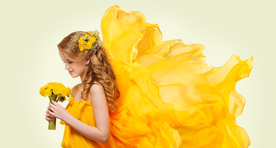 Young Girl Portrait with Yellow Flowers Dandelion Bouquet, Fashion Model Posing with Flying Fabric
