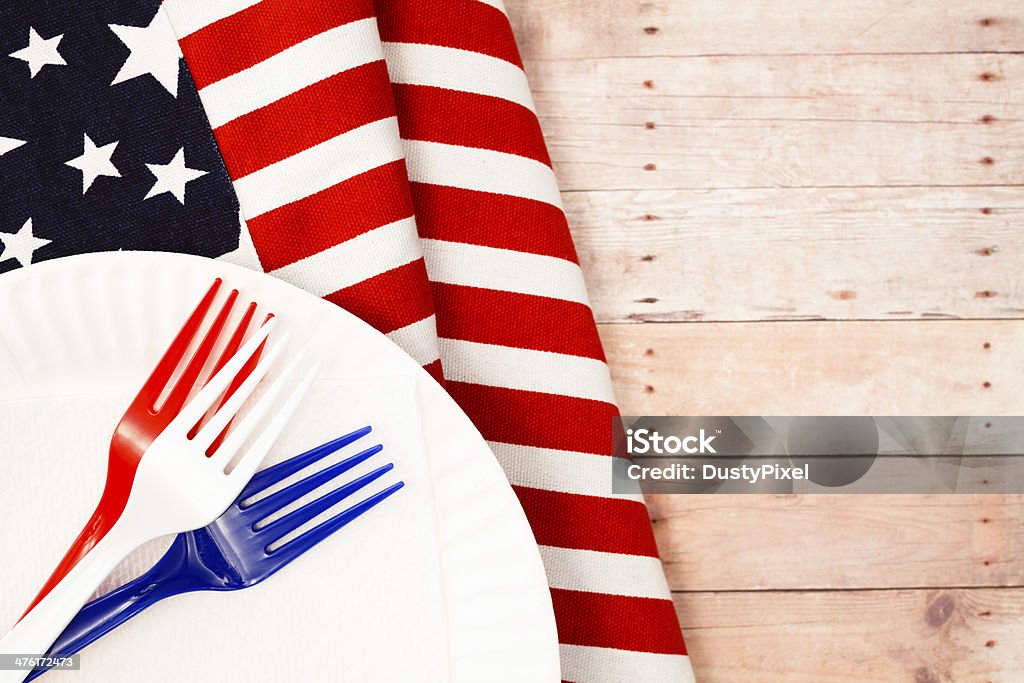 Flag and Forks Picnic table with patriotic flag table cover and red, white and blue plastic forks American Flag Stock Photo