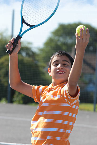 istock Boy holding tennis ball and racket 476182179