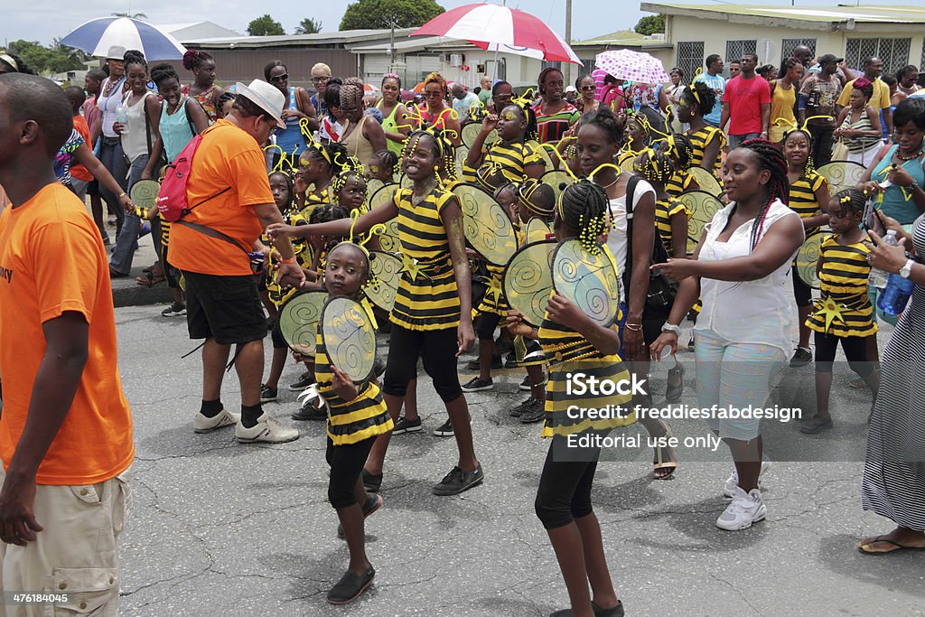 busy bees St. Michael, Barbados - July 27, 2013: A group with kids dressed up with bee costumes walking along with parents in the kids kadooment in Barbados Barbados Stock Photo