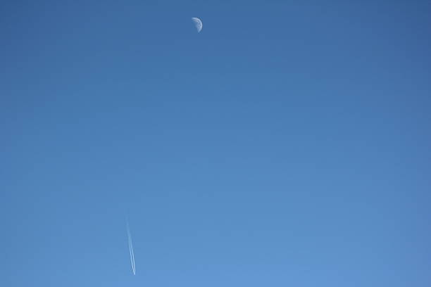 istock Blue Clear Sky, Moon & White Condensation Trail of Aircraft 476184253