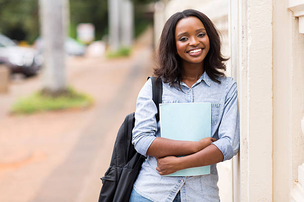 istock female african american college student holding a book 476187818
