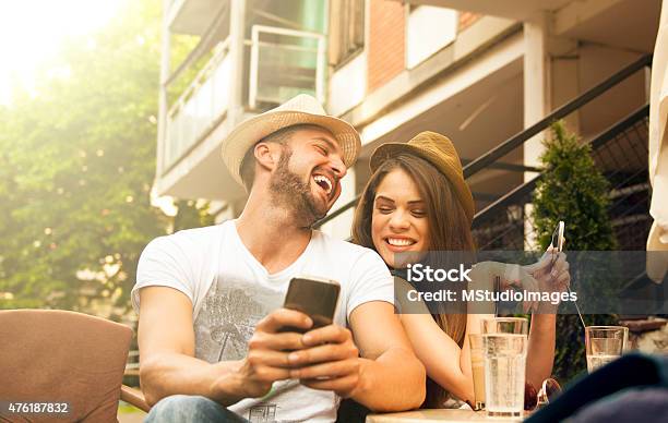 Young Happy Couple At Cafe Using Smartphone Stock Photo - Download Image Now - Couple - Relationship, Cafe, Two People