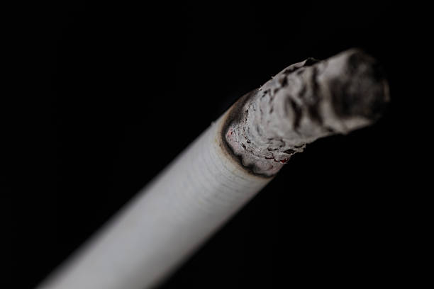 istock Burning cigarette with smoke on black background 476187898