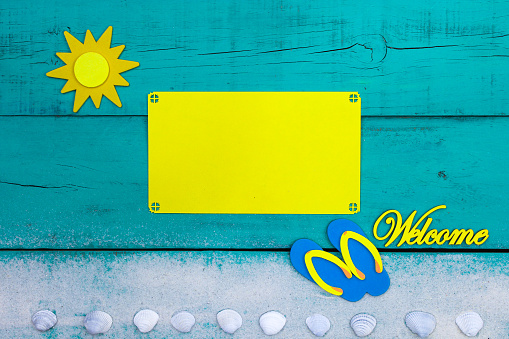 Blank yellow beach sign with sand, seashells, welcome and sandals border