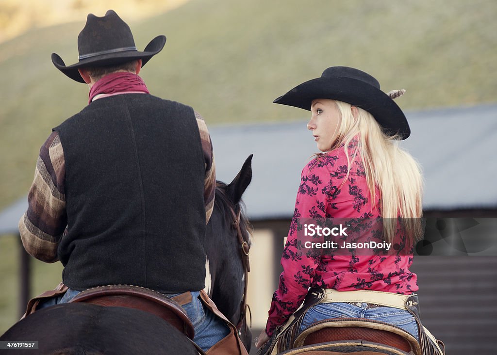 Cowgirl and Cowboy on Horseback A cowboy and cowgirl sitting on horseback in the early morning. 20-29 Years Stock Photo