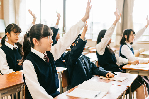 Japanese Junior High School Students Raising hands in Classroom