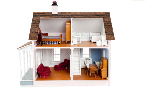 A Child's doll house with furniture on a white background