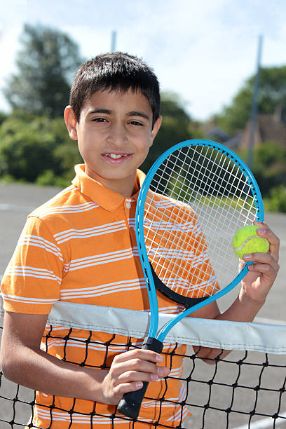 istock Boy holding tennis ball and racket 476196265