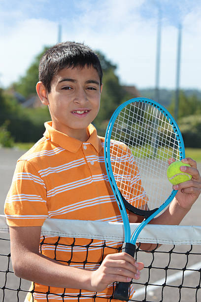 istock Boy holding tennis ball and racket 476196273