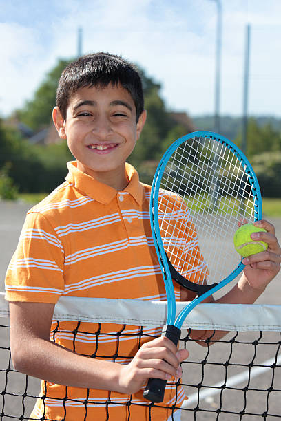 istock Boy holding tennis ball and racket 476196301