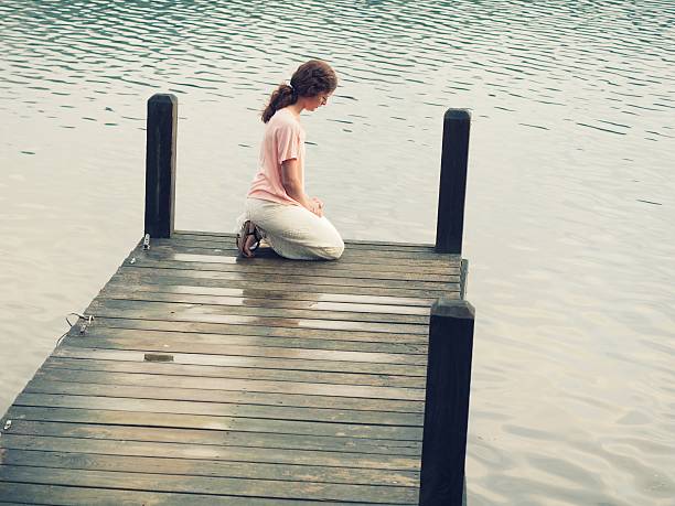 istock Woman In Prayer On Dock 476196670
