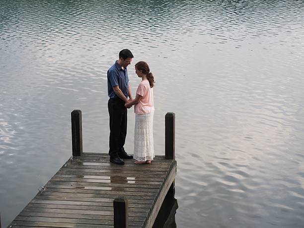istock Couple Praying Together By Lake 476196686