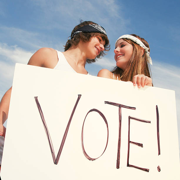 os adultos jovens segurando sinal ao ar livre durante a campanha de votação - jovens a votar imagens e fotografias de stock