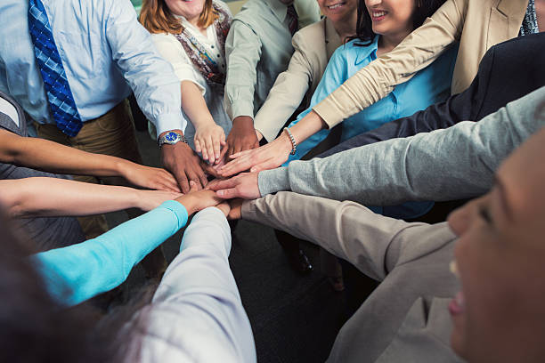 istock Diverse team of businesspeople with hands in teamwork huddle 476197766