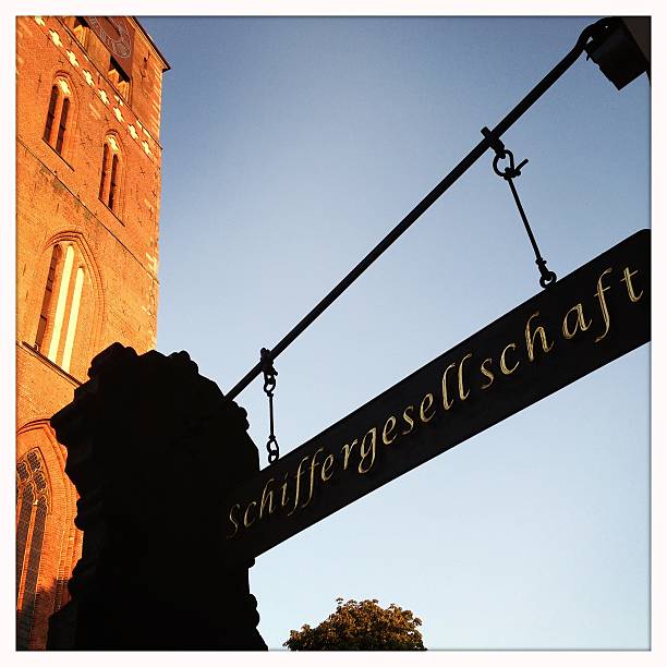 Lubeck, Germany - July 20, 2013: Sign advertising the popular restaurant Schiffergesellschaft. The restaurant is located at Breite Straße 2 right opposite of the landmark church Jacobikirche (St Jacobi Church), that can be partly seen to the left in the image.
