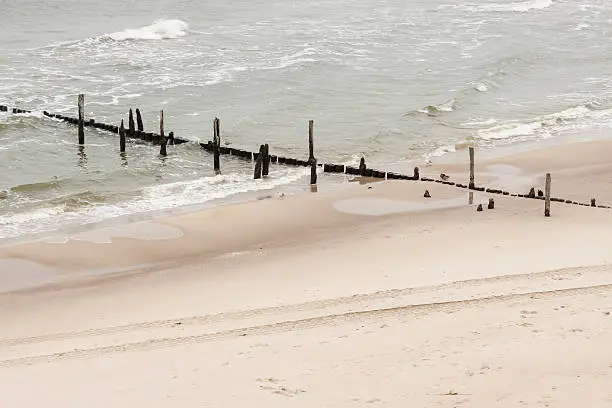 Golden sandy Baltic beach, wooden breakwater - Rewal, Poland.