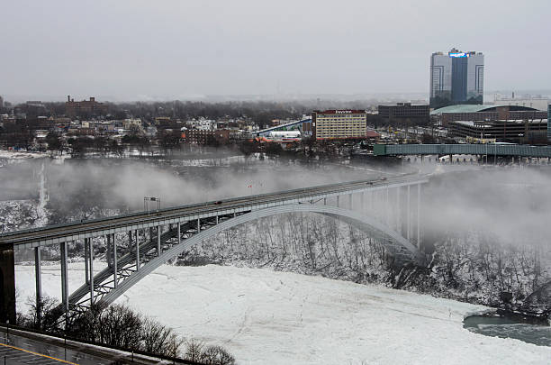 Rainbow Bridge Rainow Bridge in Ontario, Canada: Jan. 11, 2014: The Rainbow bridge over the frozen Niagara River frozen river stock pictures, royalty-free photos & images