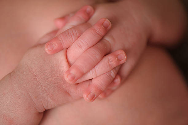 istock Macro Closeup of Newborn With Hands Interlocked 476209365
